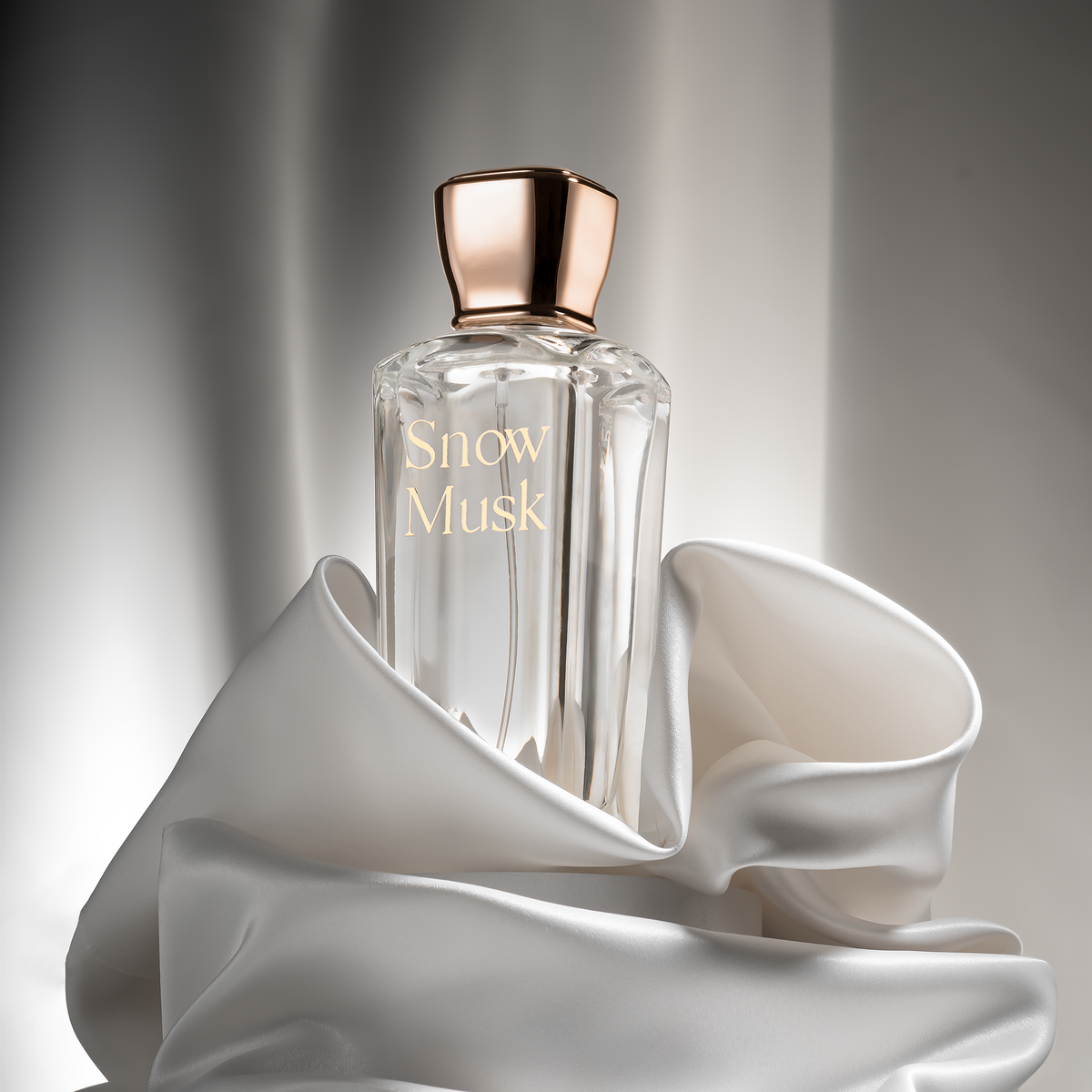 Snow Musk Eau de Parfum 75 ml in white satin fabric on a grey background