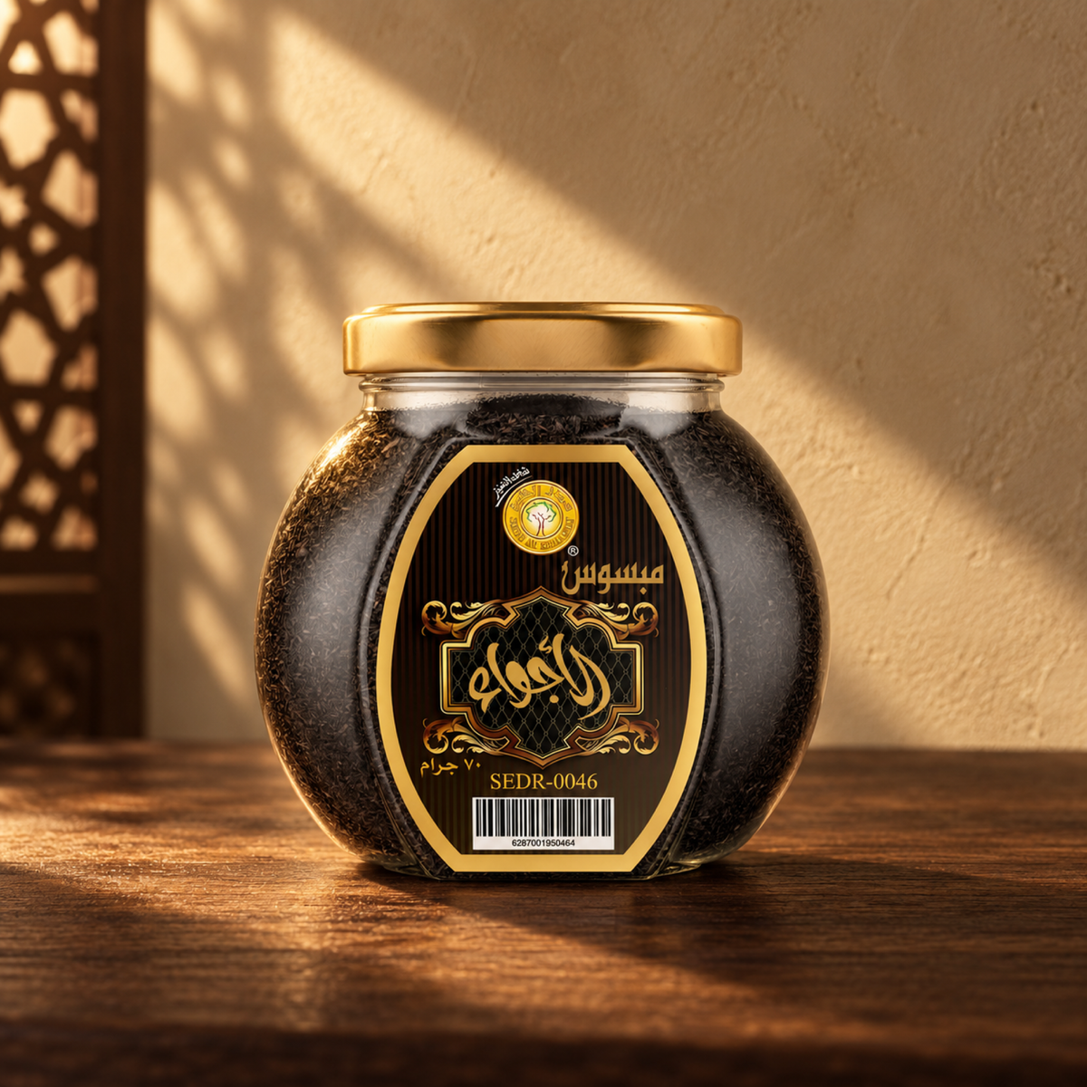 Al Ajwaa Mabsos 70 g from Sedr Al-Khaleej; round glass jar with a black and gold label and gold lid on walnut wood against a sand-coloured wall.