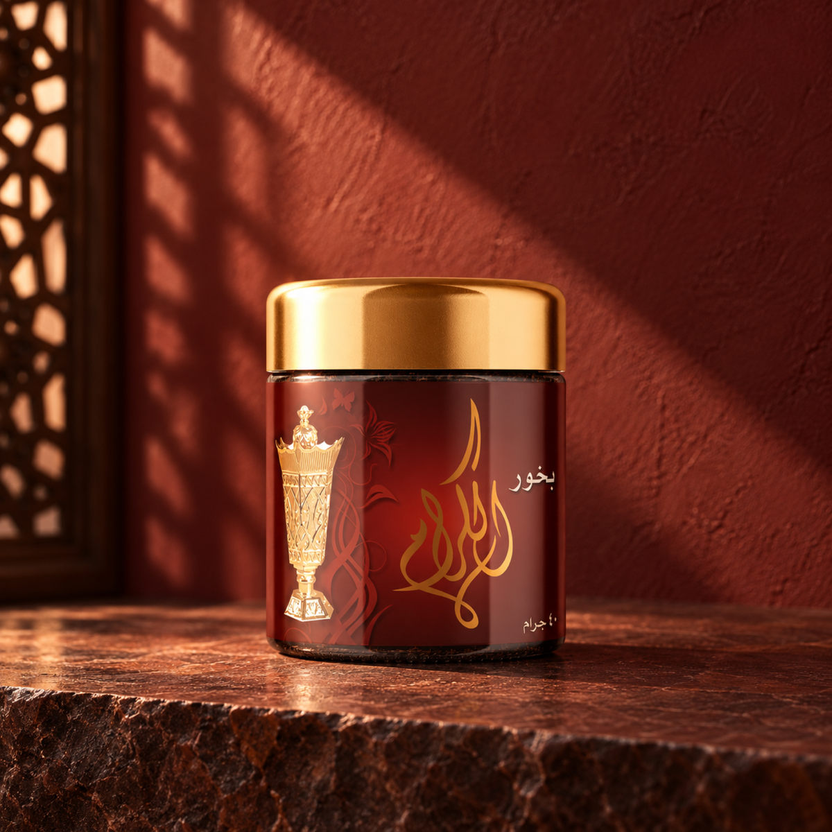 Al-Keram Bakhoor 40 g from Sedr Al-Khaleej; incense jar with a gold lid on maroon stone against a dark red sunlit wall.