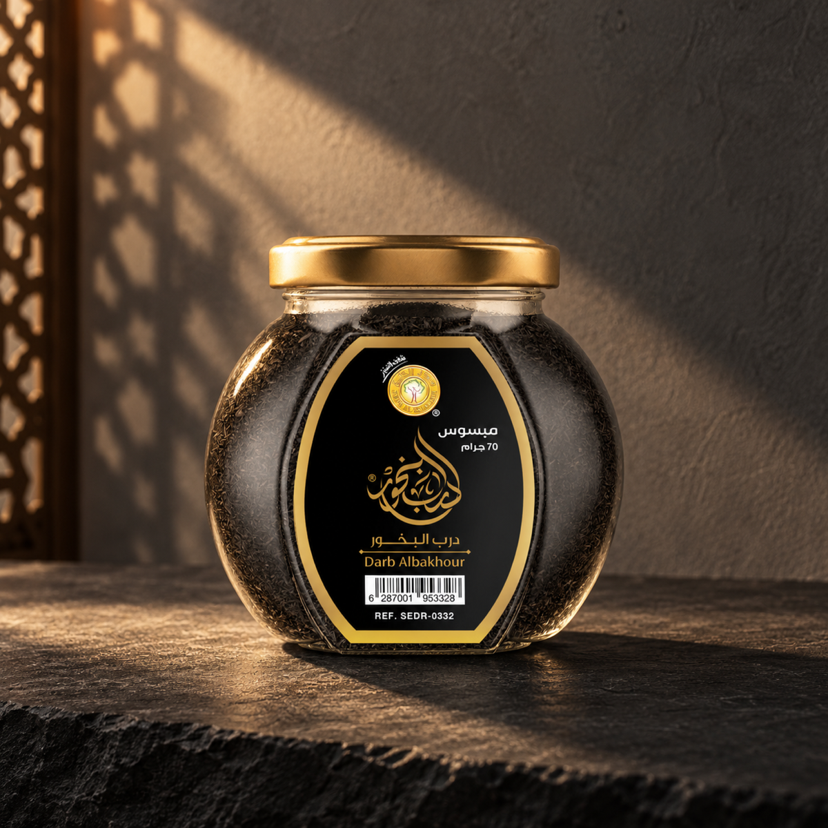 Darb Al-Bakhoor Mabsos 70 g from Sedr Al-Khaleej; closed jar with a gold lid on dark slate against a charcoal plaster wall, with a sunbeam and wooden screen shadow on the left.