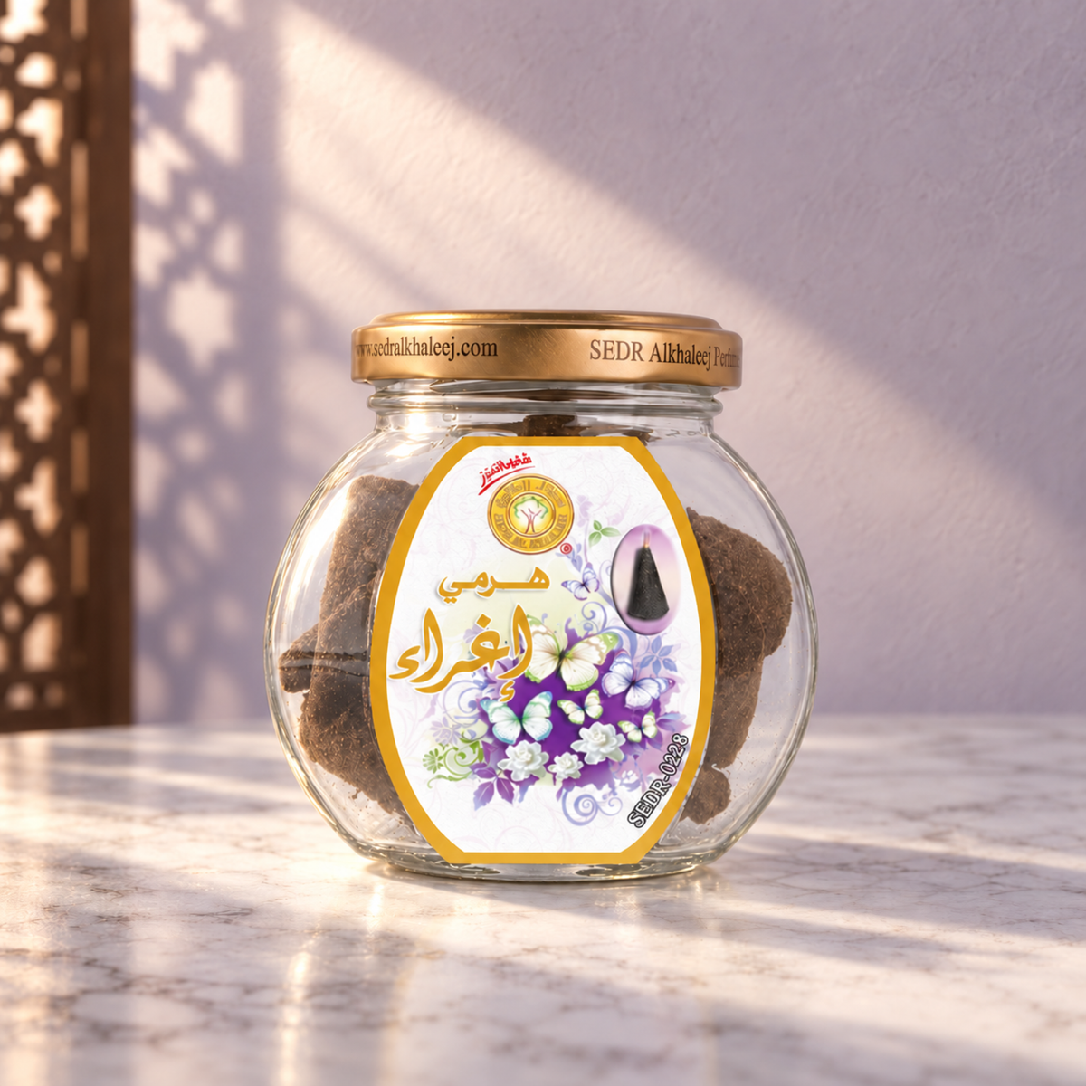 Eghra Pyramid Maamoul 50 g from Sedr Al-Khaleej; round glass incense jar with a white and violet label and gold lid on white marble against a lilac wall.