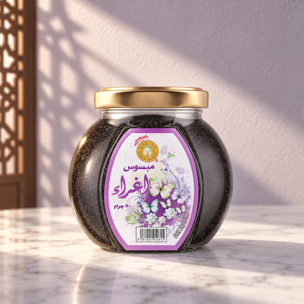 Eghra Mabsos 70 g from Sedr Al-Khaleej; closed jar with a purple label and gold lid on white marble against a pale lilac plaster wall, with angled sunlight and a wooden screen shadow.