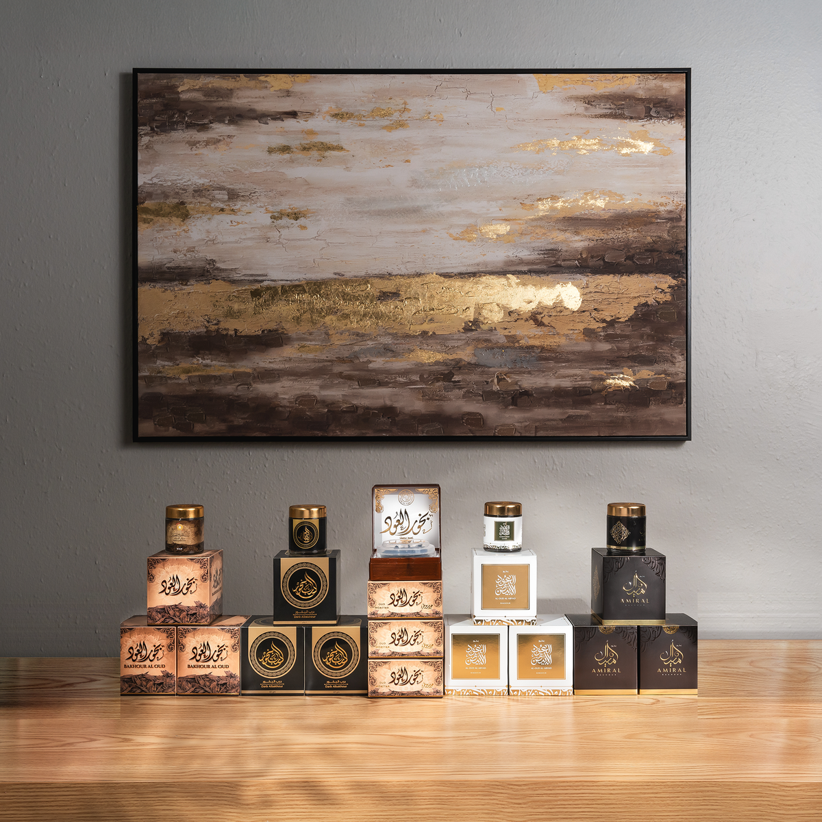 Mosques Bundle: bakhoor jars, boxes and scented oud lined up on a wooden shelf below a painting on a grey wall