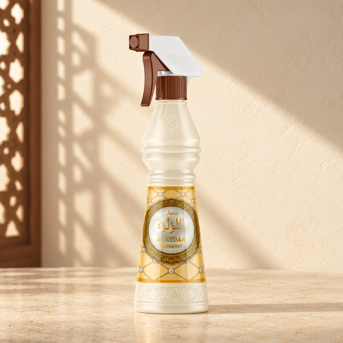 Al-Lulua Air Freshener 500 ml from Sedr Al-Khaleej; spray bottle with a gold label on cream stone against a pale sunlit wall.