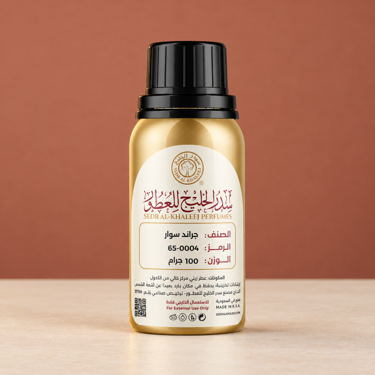 Sedr Al-Khaleej grand soir perfume oil gold bottle on matte cream ceramic, against plain dusty terracotta sweep