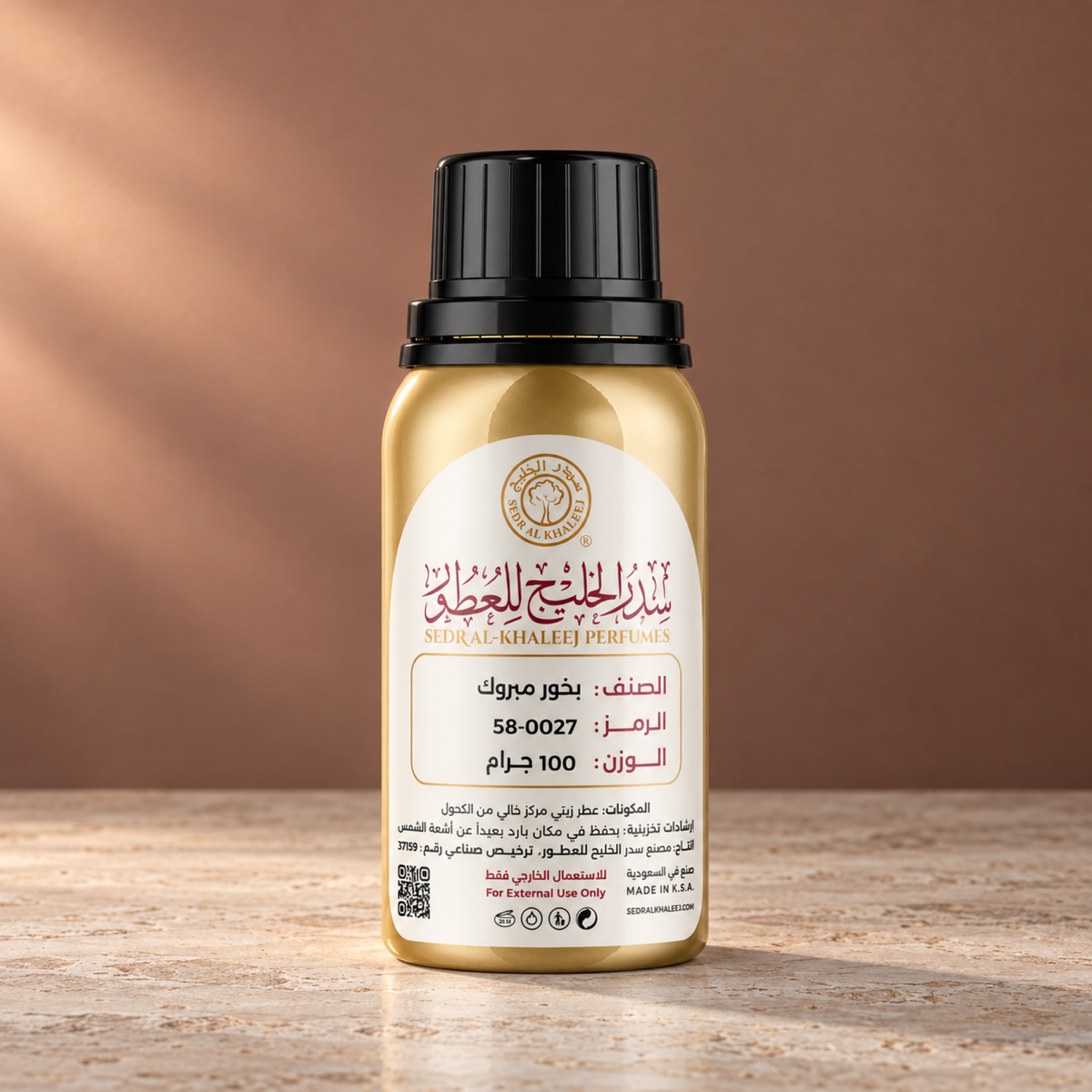 Sedr Al-Khaleej mabrook perfume oil; one closed original bottle on pale grey travertine, against plain muted bronze rose-brown wall.