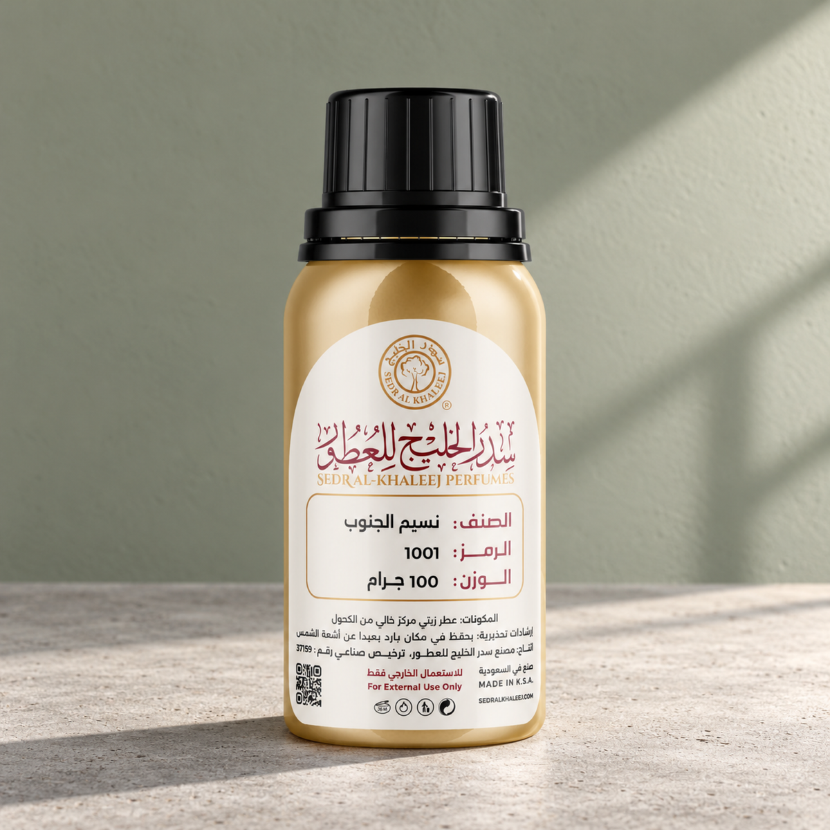 Sedr Al-Khaleej naseem aljanob perfume oil; one closed original bottle on warm-grey matte concrete before a muted sage, light clay grey backdrop.