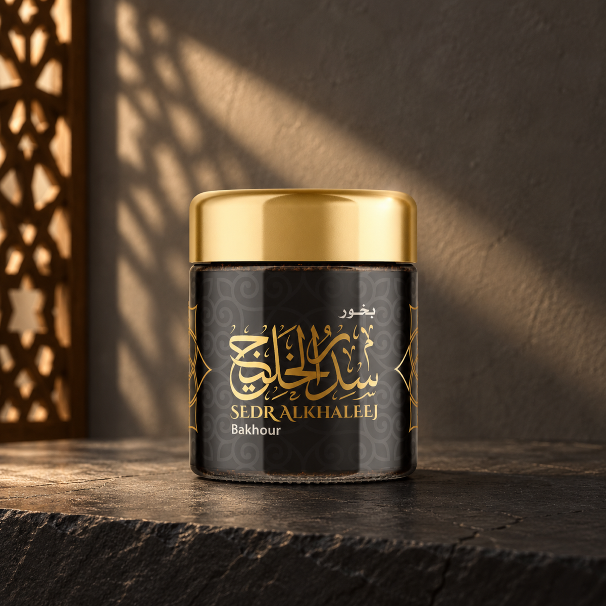 Sedr Al-Khaleej Bakhoor 40 g; black incense jar with a gold lid on dark slate against a charcoal wall in angled sunlight.