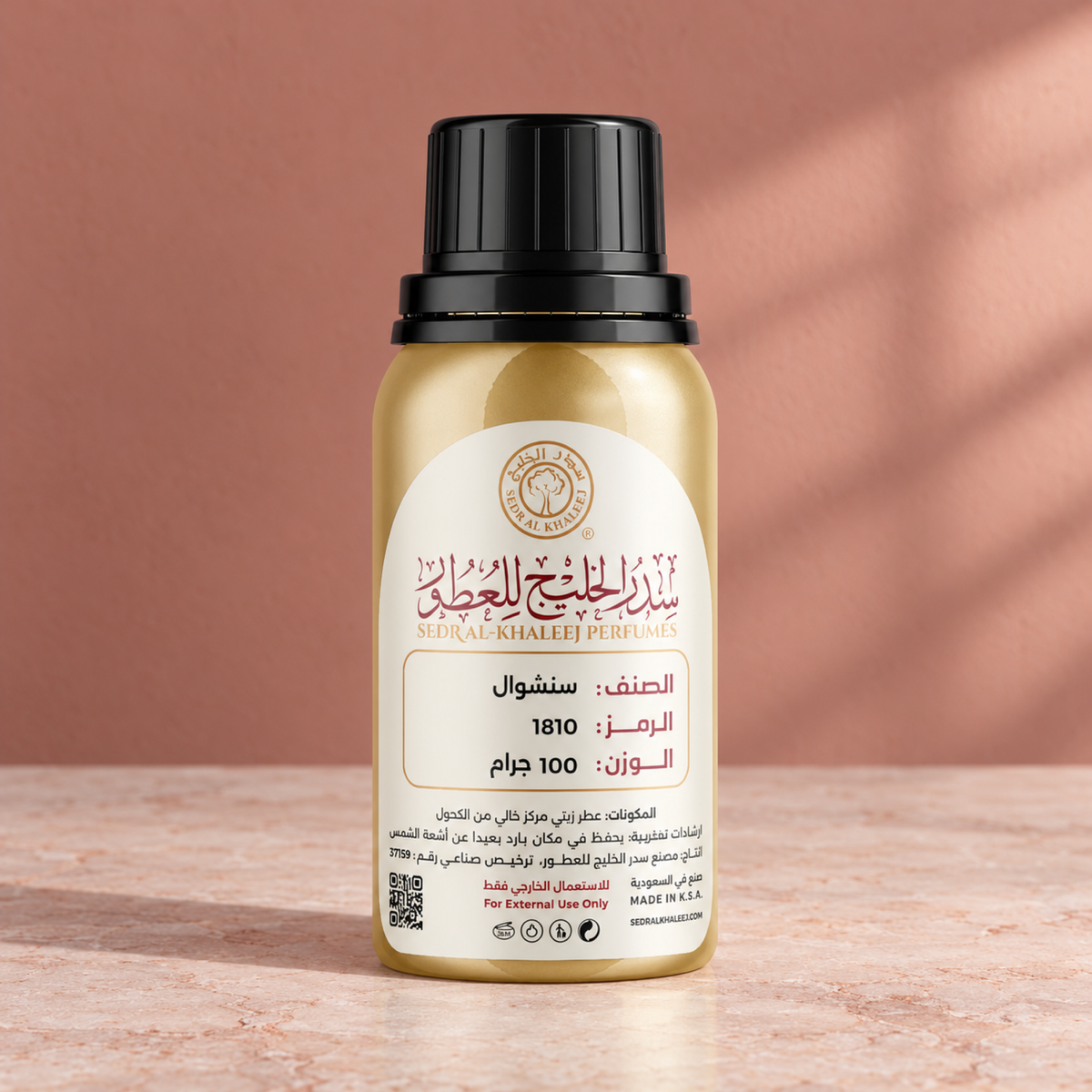 Sedr Al-Khaleej sensual perfume oil; one closed original bottle on pale blush mineral stone before a dusty coral, faint sage grey backdrop.